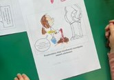 Dziewczynka koloruje tematyczną kolorowankę związaną z Dniem Praw Dziecka.